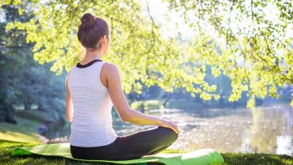Fitness für die Seele - Mentales Training - eine Frau entspannt sich im Park