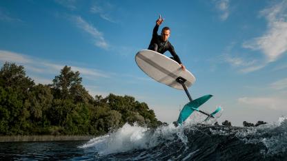 Hydrofoil-Surfing - Mann auf Brett springt aus dem Wasser