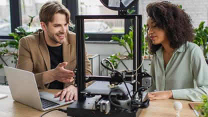 3D-Drucker - Frau und Mann benutzen einen 3D-Drucker
