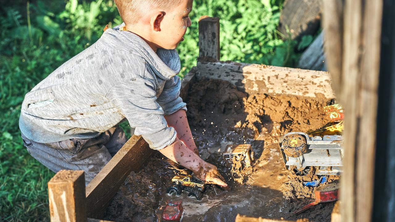 DIY Matschküche - Junge matscht mit Autos in Matschküche