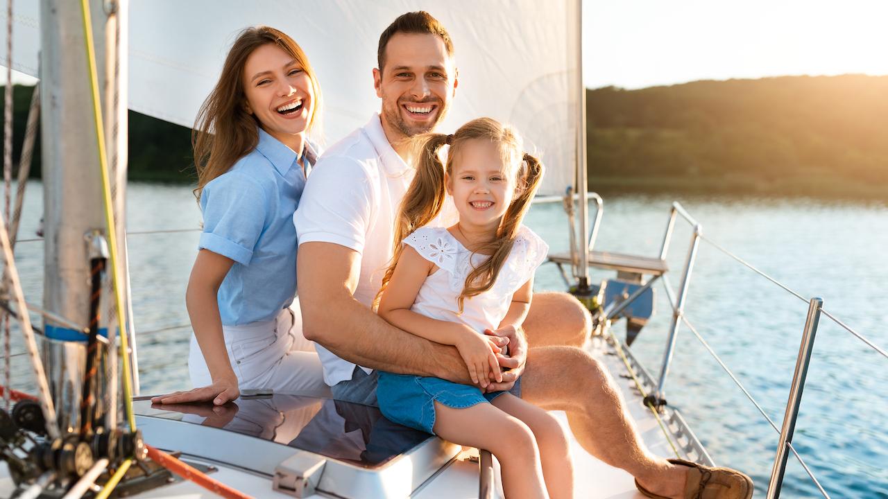 Ein Ausflug mit dem Boot - glückliche Familie sitzt auf Boot