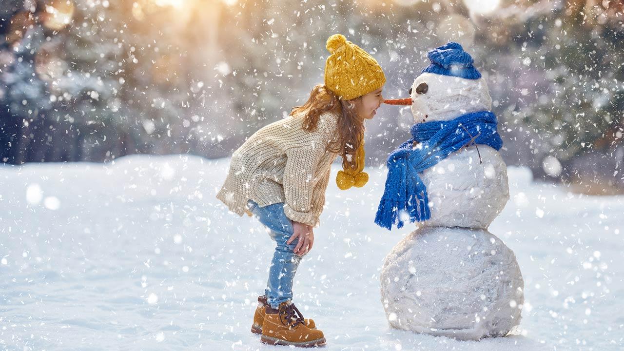 Mit den Kindern einen Schneemann bauen - Mädchen