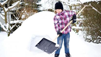 Iglu im Garten selbst bauen - Mädchen mit Schneeschaufel