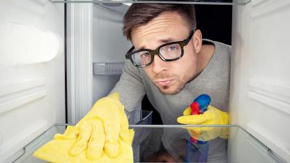 Frühjahrsputz im Kühlschrank  - Mann putzt