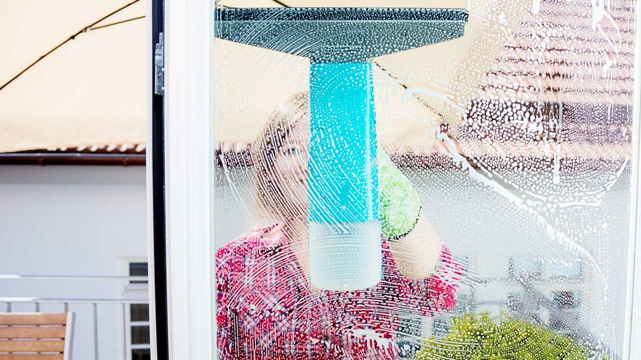 Fenster einfacher putzen mit Fenstersauger - Frau putzt von außen