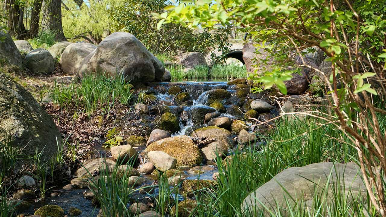 Fließende Gewässer im eigenen Garten / Bachlauf über Felsen