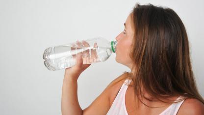Wie schütze ich mich vor der Sommerhitze ? / Frau trinkt Wasser