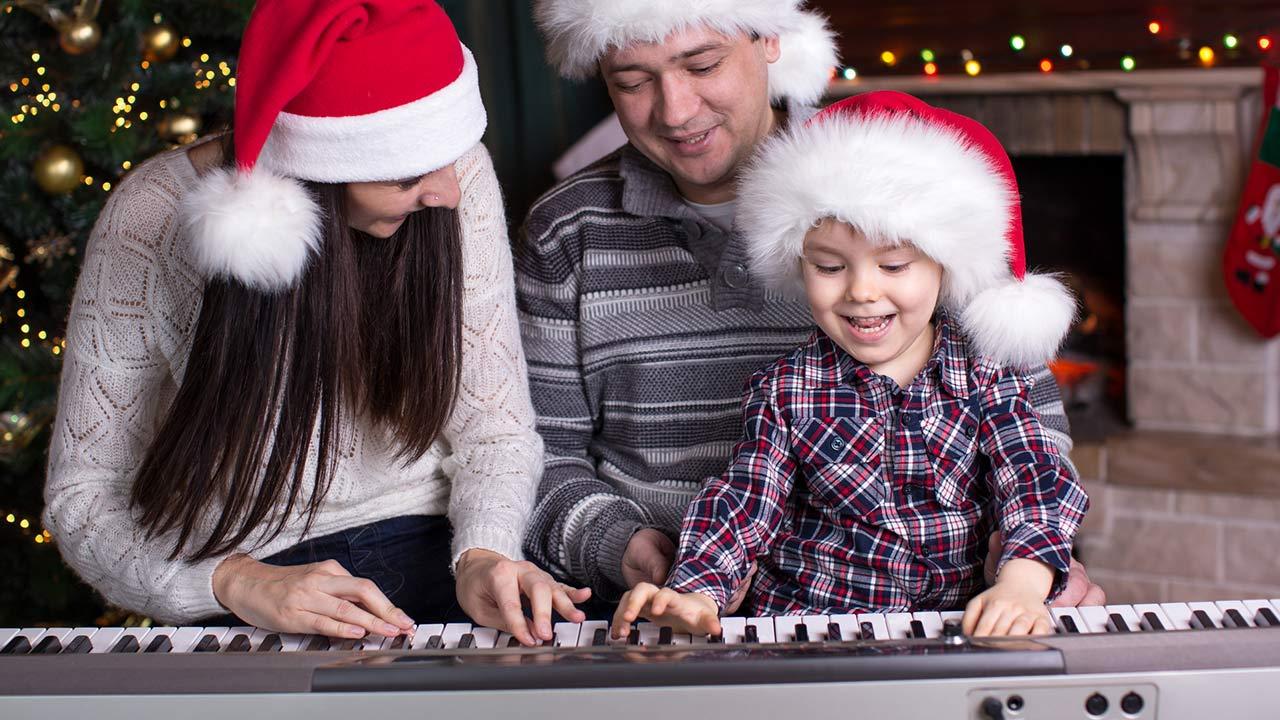 Die schönsten Weihnachtslieder / Eltern spielen mit ihrem Kind am Klavier Weihnachtslieder
